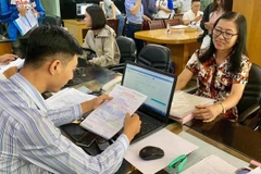 Bà Đào Thị Thư làm thủ tục đăng ký xét tuyển tại Trường Đại học Văn Hiến. (Nguồn: SGGP)