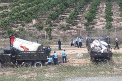 Các lực lượng chức năng thu thập các mảnh vỡ máy bay để phục vụ công tác điều tra. (Ảnh: Phan Sáu/TTXVN)