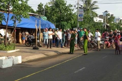 Lực lượng chức năng bảo vệ hiện trường nơi xảy ra vụ án mạng. (Ảnh: Đậu Tất Thành/TTXVN)