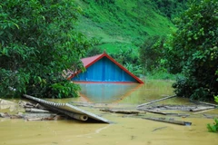 Nhà cửa, tài sản của người dân Tuần Giáo bị ngập trong nước lũ. (Ảnh: Xuân Tư/TTXVN)