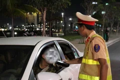 Cảnh sát Giao thông kiểm tra nồng độ cồn đối với người điều khiển xe ôtô. (Ảnh: Xuân Triệu/TTXVN)