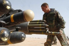 Binh sỹ Mỹ gắn tên lửa lên trực thăng Boeing AH-64 Apache. (Nguồn: AFP)