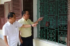 Ông Khamphanh (phải) hào hứng kể lại cho người bạn Thongdeng về chỗ ngồi ở ngôi trường cũ năm xưa họ từng học. (Ảnh: Huy Đồng/Vietnam+)