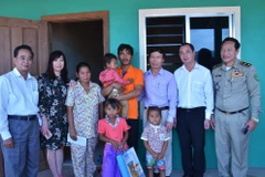 Đoàn thăm hỏi gia đình và tặng quà cháu bé bị xâm hại. (Ảnh: Phan Minh Hưng/TTXVN)