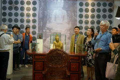 Các đại biểu tìm hiểu các hiện vật tại triển lãm 'Di sản Việt Nam - Góc nhìn mới.' (Ảnh: Đinh Thuận/TTXVN) 