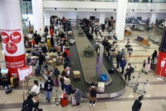 Bên trong khu vực lấy hành lý đông đúc, khiến việc di chuyển ra ngoài sảnh lâu hơn thường lệ. (Ảnh: Huy Hùng/TTXVN)