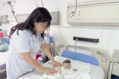 Phó Giáo sư, Tiến sỹ Nguyễn Việt Hoa, Trưởng khoa Phẫu thuật Nhi và Trẻ sơ sinh, Bệnh viện Hữu nghị Việt Đức, đang thăm khám cho bệnh nhi. (Ảnh: Bệnh viện cung cấp)