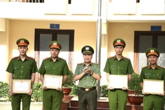 Giám đốc Công an tỉnh Đồng Nai tặng Giấy khen cho 4 cá nhân thuộc Đội Chữa cháy và cứu nạn cứu hộ khu vực Nhơn Trạch vì có thành tích cứu sống bé gái 5 tuổi rơi xuống hố cọc ép bêtông sâu 15m vào ngày 19/12 vừa qua. (Ảnh: TTXVN phát)