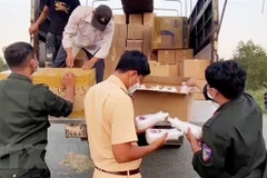 Lực lượng chức năng An Giang kiểm đếm hàng hóa không rõ nguồn gốc. (Ảnh: TTXVN phát)