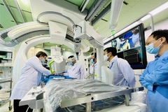 Các bác sỹ Bệnh viện Đột quỵ-Tim mạch Cần Thơ thao tác chụp DSA với sự hỗ trợ của Robot Corindus. (Ảnh: Ánh Tuyết/TTXVN)