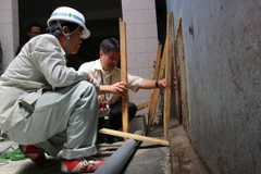 Các chuyên gia Nhật Bản phối hợp lắp đặt hệ thống quan trắc để đo độ dịch chuyển của nền đất trong khu vực đường Nguyễn Văn Trỗi. (Ảnh: Nguyễn Dũng/TTXVN)