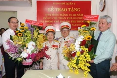 Bí thư Thành ủy TP.HCM Nguyễn Thiện Nhân tặng hoa chúc mừng ông Trần Thăng Phúc tròn 70 năm tuổi đảng và vợ là bà Hoàng Thị Hường tròn 60 năm tuổi đảng. (Ảnh: Thanh Vũ/TTXVN)