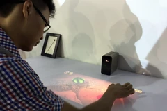 Trải nghiệm chơi trò chơi trên mặt gỗ nhờ thiết bị Xperia Touch-sản phẩm có thể "biến" mặt phẳng thành màn hình cảm ứng của Sony. (Ảnh: Trung Hiền/Vietnam+) 