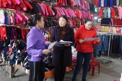 Cán bộ Bảo hiểm xã hội tuyên truyền, vận động người dân tham gia bảo hiểm xã hội tự nguyện. (Ảnh: Chu Hiệu/TTXVN)