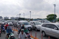 Các phương tiện ùn ứ kéo dài, di chuyển chậm trước cửa hầm vượt sông Sài Gòn. (Ảnh: Hoàng Hải/TTXVN)