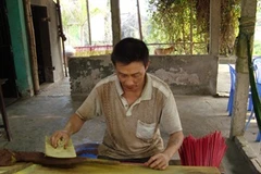 Người thợ miệt mài se hương (Ảnh: PV/Vietnam+)