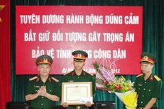 Thiếu tướng Phí Quốc Tuấn trao Bằng khen cho Thiếu úy Nguyễn Anh Tuấn (Ảnh: Sơn Bách/Vietnam+)