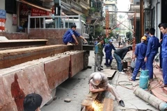 Đội xử lý chống nghiêng làm việc tại ngôi nhà nghiêng số 14/91 Nguyễn Chí Thanh (Ảnh: Sơn Bách/vietnam+)