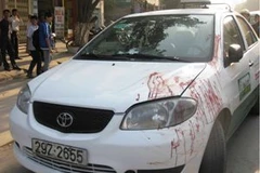 Chiếc xe taxi vẫn còn dính máu nạn nhân bị bỏ lại hiện trường (Ảnh: Sơn Bách/Vietnam+)