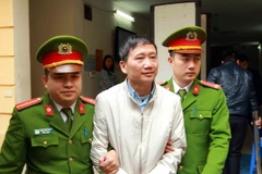 Cảnh sát dẫn giải bị cáo Trịnh Xuân Thanh về trại giam. (Ảnh: An Đăng/TTXVN)