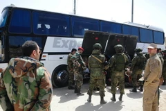 Binh sỹ Nga và Syria giám sát việc sơ tán của lực lượng nổi dậy và gia đình tại Đông Ghouta ngày 29/3. (Nguồn: THX/TTXVN)