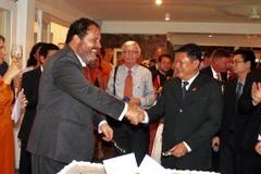 Ông Huỳnh Cách Mạng, Phó Chủ tịch UBND Thành phố Hồ Chí Minh (phải) và ông Carel Richter, Tổng lãnh sự Vương quốc Hà Lan tại Thành phố Hồ Chí Minh (trái) cắt bánh tượng trưng kỷ niệm 45 năm thiết lập quan hệ ngoại giao Việt Nam-Hà Lan. (Ảnh: Xuân Khu/TTXV