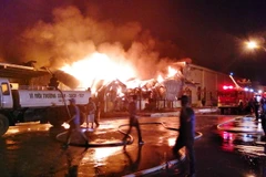 Lực lượng chức năng nỗ lực khống chế đám cháy. (Ảnh: Văn Đức/TTXVN)