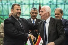 Trưởng đoàn đàm phán của Hamas, ông Saleh al-Aruri (trái) và Trưởng đoàn đàm phán của Fatah, ông Azzam al-Ahmad (phải) sau lễ ký thỏa thuận hòa giải tại Cairo, Ai Cập ngày 12/10/2017. (Nguồn: AFP/TTXVN)