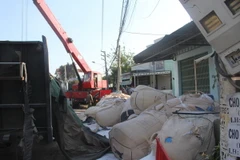 Hàng chục tấn alumin đổ tràn ra đường. (Ảnh: Đặng Tuấn/TTXVN)