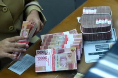 Kiểm đồng rupiah tại một trung tâm thu đổi ngoại tệ ở Jakarta. (Nguồn: Antara)
