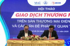 Đại diện ITPC và VECOM ký kết bản ghi nhớ hợp tác (MOU). (Ảnh: Mỹ Phương/TTXVN)