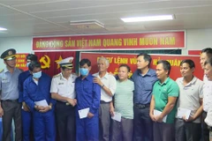 Chuẩn đô đốc Ngô Văn Thuân và lãnh đạo các cơ quan tìm kiếm cứu nạn và địa phương động viên tinh thần các ngư dân gặp nạn đã trở về đất liền an toàn. (Ảnh: Phan Sáu/TTXVN)