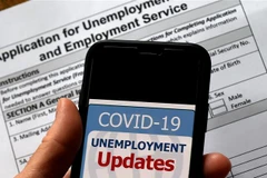 Cập nhật tình hình mất việc làm do dịch COVID-19 trên điện thoại tại Arlington, bang Virginia, Mỹ. (Ảnh: AFP/TTXVN)