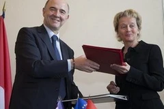 Bộ trưởng Tài chính Pháp Pierre Moscovici và người đồng cấp Thụy Sĩ Eveline Widmer-Schlumpf tại buổi ký thỏa thuận. (Nguồn: swissinfo.ch)