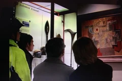 Khách tham quan xem bức tranh “Gióng” của Họa sĩ Nguyễn Tư Nghiêm. (Ảnh: Đỗ Sinh/Vietnam+)