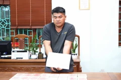 Đối tượng Cứ A Anh và tang vật 16 bánh heroin. (Ảnh: Nguyễn Oanh/TTXVN) 