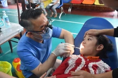 Các bác sỹ tiến hành thăm, khám răng cho trẻ em tại Đắk Lắk. (Ảnh: Nguyên Dung/TTXVN)