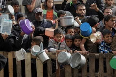 Người dân chờ nhận thực phẩm cứu trợ tại thành phố Rafah, Dải Gaza. (Ảnh: THX/TTXVN)
