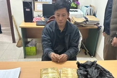 Đối tượng Lý A Phừ cùng tang vật vụ án. (Ảnh: TTXVN phát)