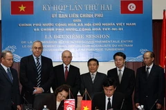 Thứ trưởng Bộ Công Thương Lê Dương Quang và Quốc Vụ khanh phụ trách đối ngoại Tunisia Saida Chtioui ký biên bản. (Ảnh: Trần Việt/TTXVN)