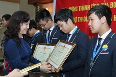 Thứ trưởng Bộ Giáo dục và Đào tạo Nguyễn Thị Nghĩa trao Bằng khen của Bộ cho các học sinh đoạt giải. (Ảnh: Quý Trung/TTXVN)