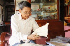 Ông Phạm Thoại Tuyền giới thiệu về thư tịch cổ về Hoàng Sa và Trường Sa đang lưu giữ. (Ảnh: Đoàn Hữu Trung/Vietnam+)