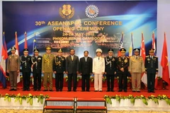 Phó Thủ tướng kiêm Bộ trưởng Bộ Nội vụ Campuchia Sar Kheng (thứ 6 từ trái) chụp ảnh cùng các đại biểu dự Hội nghị. (Ảnh: THX/TTXVN) 