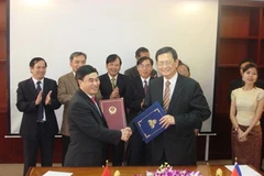 Thứ trưởng Hồ Xuân Sơn và Bộ trưởng cao cấp Var Kimhong trao đổi Thỏa thuận về việc sản xuất bộ bản đồ biên giới VN-Campuchia. (Ảnh: Trần Chí Hùng/Vietnam+)