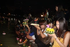 Người dân tham gia lễ hội Loy Krathong, thắp hương nến và thả đèn hoa đăng xuống nước ở một công viên tại trung tâm Bangkok. (Ảnh: Ngọc Tiến/Bangkok)