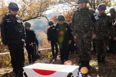 Binh sỹ Hàn Quốc mặc niệm tưởng nhớ đồng đội sau khi tìm thấy một bộ hài cốt được cho là binh sỹ tử trận trong cuộc chiến tranh Triều Tiên (1950-53) tại khu phi quân sự ở biên giới liên Triều ngày 25/10 vừa qua. (Ảnh: Yonhap/TTXVN )