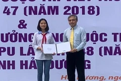 Thứ trưởng Bộ Thông tin và Truyền thông Nguyễn Minh Hồng trao giải ba quốc tế Cuộc thi Viết thư quốc tế UPU 47 - năm 2018 cho em Nguyễn Thị Bạch Dương, học sinh Trường THCS Nguyễn Trãi, huyện Nam Sách. (Ảnh: Hiền Anh/TTXVN)
