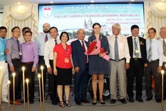 Ông Huỳnh Minh Thiện, Chủ tịch Liên hiệp các Tổ chức Hữu nghị Thành phố Hồ Chí Minh (giữa) và bà Olga Chojnacka, Bí thư thứ nhất, Trưởng phòng Lãnh sự Đại sứ quán Séc tại Việt Nam chụp ảnh cùng Ban Chấp hành Hội hữu nghị Việt-Séc TP.HCM. (Ảnh: Xuân Khu-TT