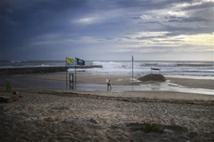 Người dân dỡ bỏ các tấm biển quảng cáo dọc bờ biển tại Costa da Caparica của Bồ Đào Nha trước bão Leslie ngày 13/10. (Ảnh: AFP/TTXVN)