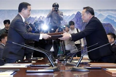 Bộ trưởng Thống nhất Hàn Quốc Cho Myoung-gyon (trái) và Chủ tịch Ủy ban Tái thống nhất hòa bình Ri Son-gwon (phải) trao đổi văn kiện sau hội đàm cấp cao liên Triều ở làng đình chiến Panmunjom ngày 15/10. (Ảnh: Yonhap/TTXVN)